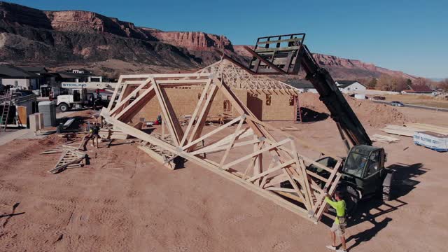 一名起重机，叉车操作员，提高新建桁架，由建设框架在一个新家园正在建造视频下载