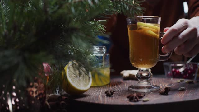 人们正在用手准备柠檬和蜂蜜的圣诞风味茶视频下载