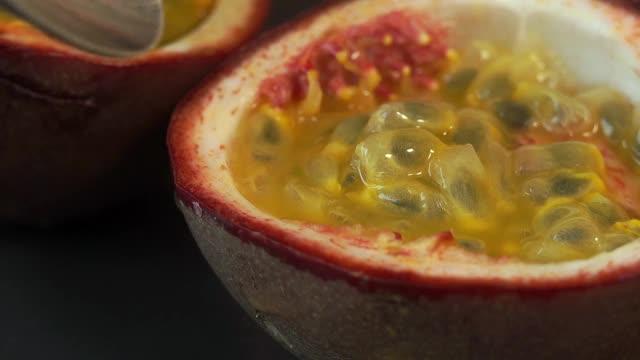 近距离舀出多汁的新鲜百香果果肉。热带、异国水果概念。视频素材