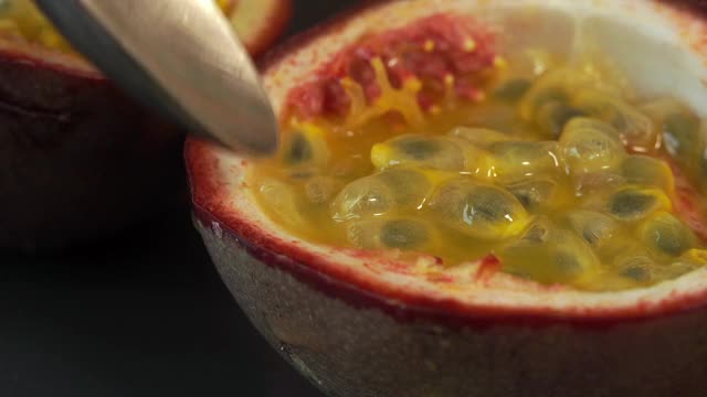 靠近的勺子与多汁的成熟的新鲜百香果果肉。热带、异国水果概念。视频素材