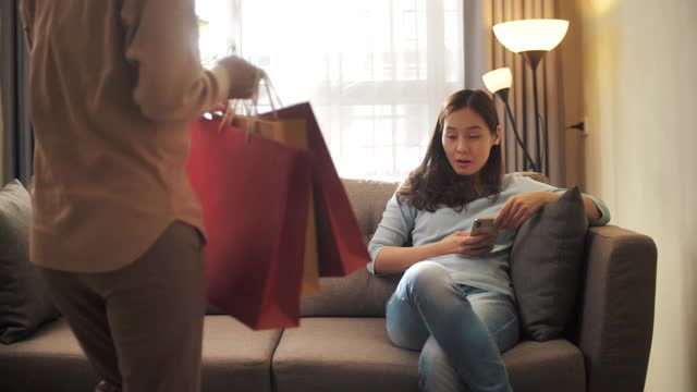 两个亚洲女人在家里购物购物袋视频素材
