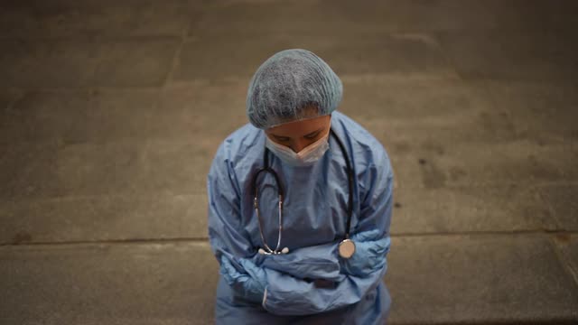 疲惫的女护士或医生在上夜班时坐在医院附近视频素材