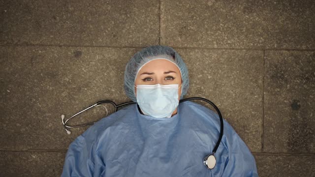 受惊吓疲惫的女医生惊恐地躺在医院附近的地上视频下载