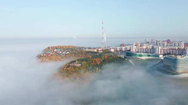 美丽的城市在雾中被森林包围。视频下载