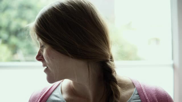 一个微笑的女人拿着阳性妊娠测试。视频下载