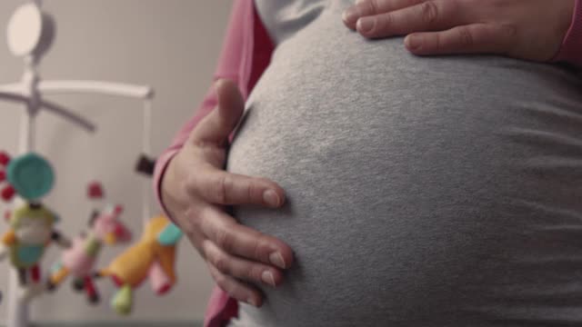 孕妇摸着自己的肚子。视频素材