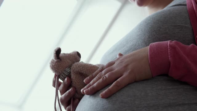 一名孕妇爱抚着她的小腹。视频素材