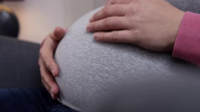 孕妇爱抚着自己的肚子。视频素材