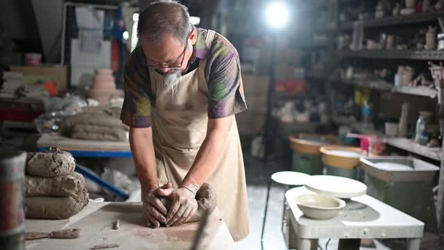 亚洲华人高级泥塑艺术家在他的工作室准备与粘土视频素材