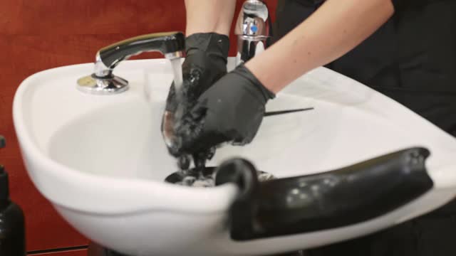 近距离视频女性与手套清洁工具在洗发水洗涤槽视频素材