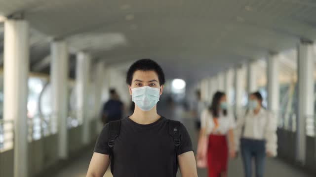 一名戴着防护面具的年轻人在城市街道上抗议视频素材