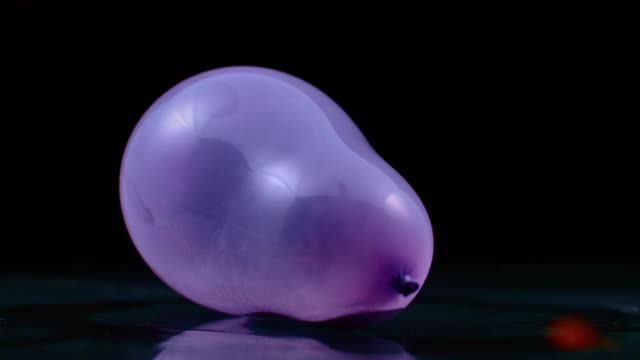 SLO MO LD紫色气球爆炸并加速燃烧视频下载