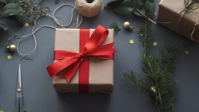 女人准备圣诞礼物。圣诞背景，礼盒和松树树枝视频下载