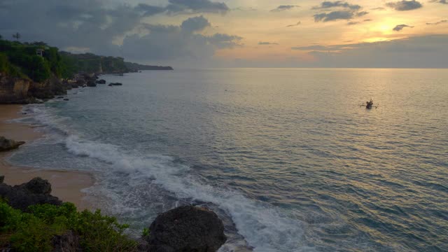 小岛附近美丽的日落，热带海滩上的小船在海水中视频下载