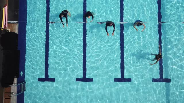 无人机的角度正上方游泳池教练指导她的学生游泳技能视频素材