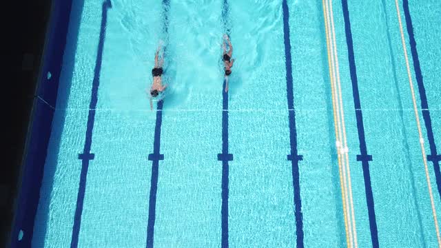 正上方无人机拍摄亚洲华人游泳运动员在游泳池游泳视频素材