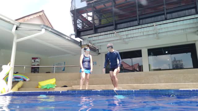 亚洲华人老夫妇跳进泳池愉快地享受视频下载