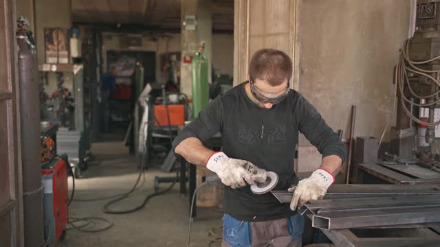 工业焊工在他的焊接车间里打磨金属棒视频素材