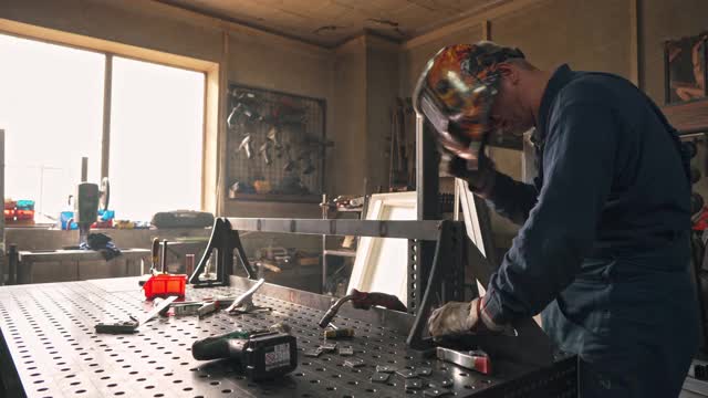 带防护服的聚焦焊机用焊枪焊接金属框架视频素材