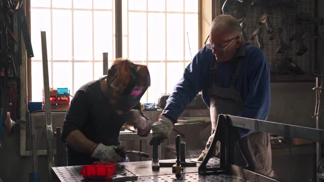 两名工程师使用他们的工作工具一起在一个金属建筑上工作视频素材
