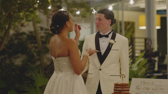 英俊的丈夫喂他的妻子一口他们的婚礼饼干蛋糕视频下载