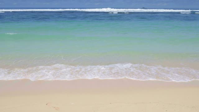 近距离观看干净的沙子和蓝色的水在海滩上与小波浪视频下载