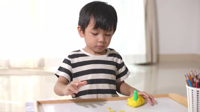 蹒跚学步的小男孩在玩粘土视频素材