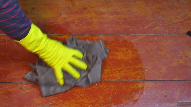 用戴橡胶手套的布擦地板。手工清洗木地板。女性的家庭作业。洗涤剂。国内女性劳动力。乳胶手套。受气包。视频。视频素材
