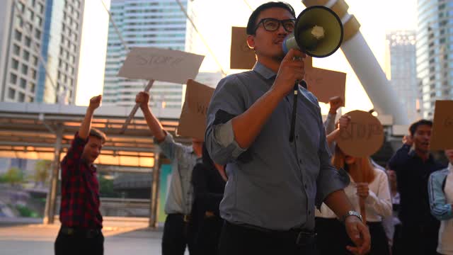 工人们在抗议，要求得到什么领导人在前面举着扩音器。视频素材