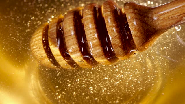 蜂蜜棒在蜂蜜中旋转，健康健康的甜品，天然产品视频素材