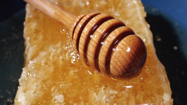 蜂蜜棒旋转天然蜂巢与蜂蜜，健康的甜点视频下载