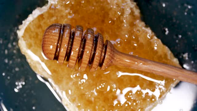 蜂蜜棒旋转天然蜂巢与蜂蜜，健康的甜点视频素材