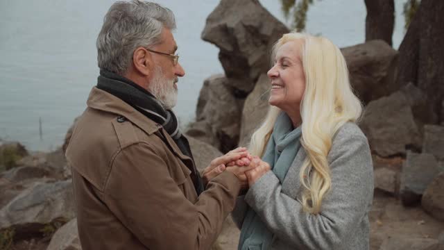 白发男子亲吻妻子的双手，爱在年事已高，感情温柔视频素材
