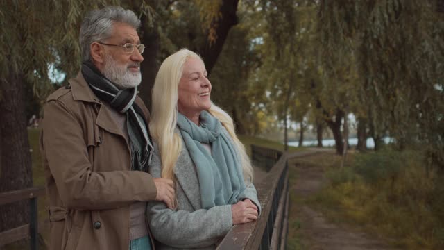 快乐的成熟夫妇在公园看湖，在乡村一起放松视频素材