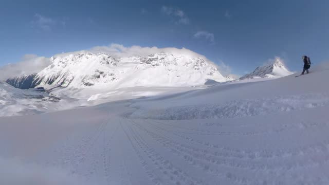 在加拿大美丽的群山中，滑雪板在未被开发的地形上滑行。视频素材