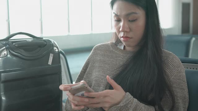 一名东南亚妇女在机场内等待飞机视频素材