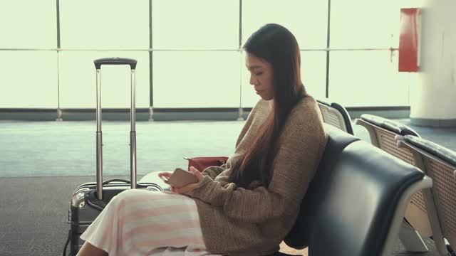 一名东南亚妇女在机场内等待飞机视频素材