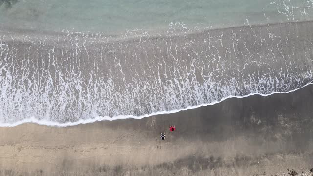 一个孩子在沙滩上玩耍的鸟瞰图视频下载
