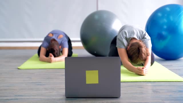 健身教练在线教一群人瑜伽。人们通过视频会议和教练练习瑜伽。视频素材