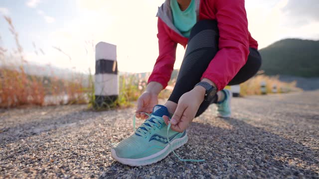女人系着她的运动鞋准备在早上跑步时间视频素材