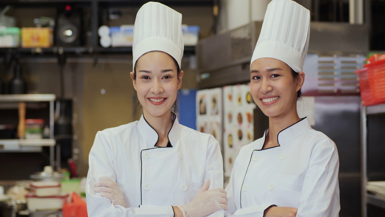 女团队厨师的肖像看着镜头微笑在现代厨房。视频素材