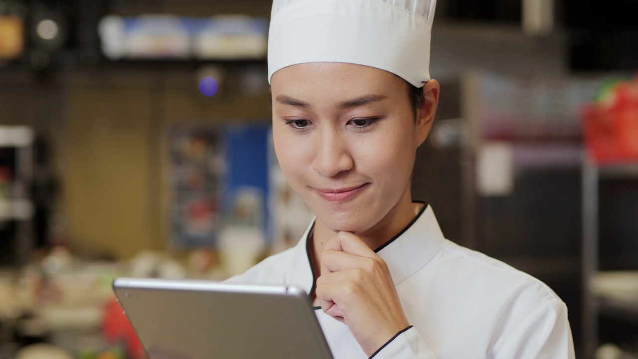 女厨师在现代厨房使用平板电脑。视频下载
