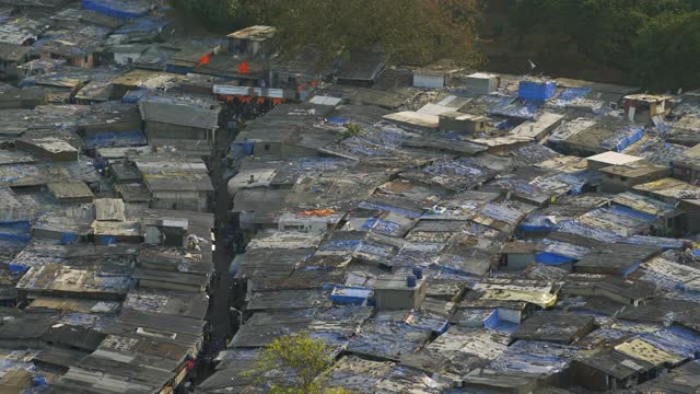 高海拔的潘:人们走在狭窄的街道之间的摇摇欲坠的建筑物在阳光日-孟买，印度视频下载