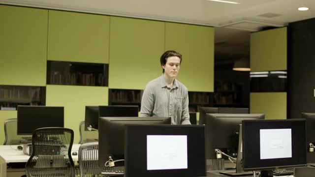 在计算机实验室使用计算机的年轻专业人员视频素材