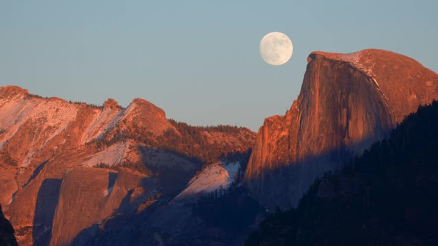 满月升起近日落旁边的半圆顶，极端远摄视图，约塞米蒂山谷，近隧道视图观景台，约塞米蒂国家公园，加州，4K视频视频下载
