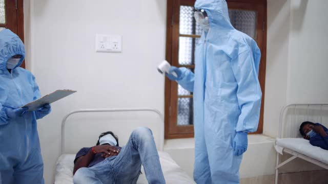 医生进病房查房检查诊断某冠状病毒感染的患者躺在病床上，检测结果为covid-19阳性视频素材
