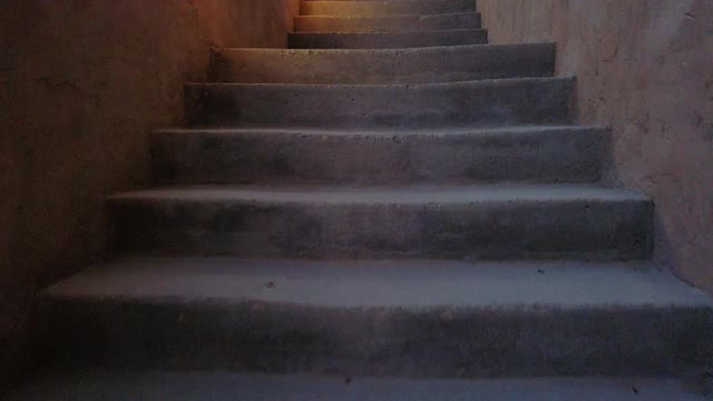 走在诡异黑暗的楼梯，旁边有灯视频素材