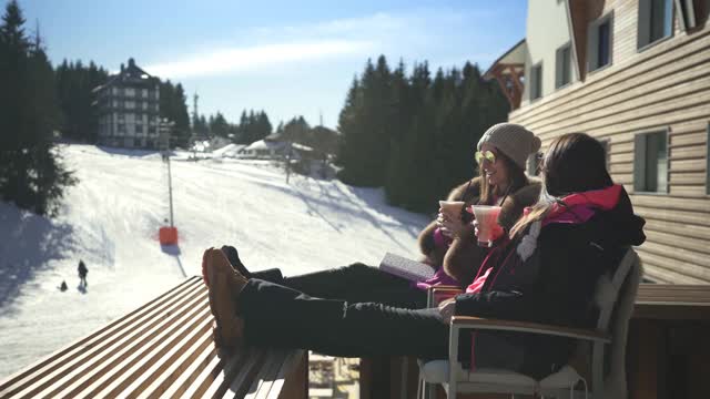 两个美丽的女人在滑雪胜地享受视频素材