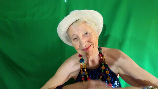 快乐的笑着滑稽的老女人戴着珠子跳舞视频素材