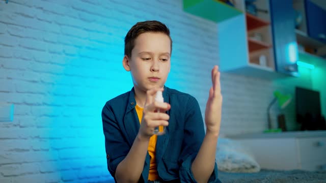 洗手液。用酒精喷雾剂洗手的男孩预防新冠病毒传播的措施。视频素材